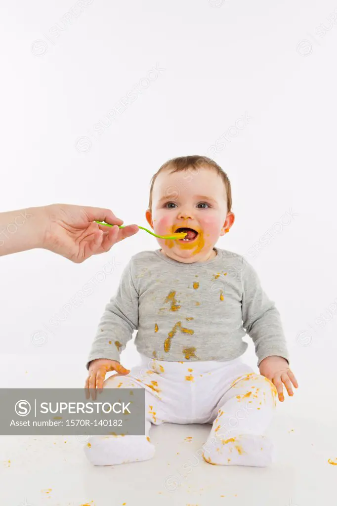 An adult feeding a baby