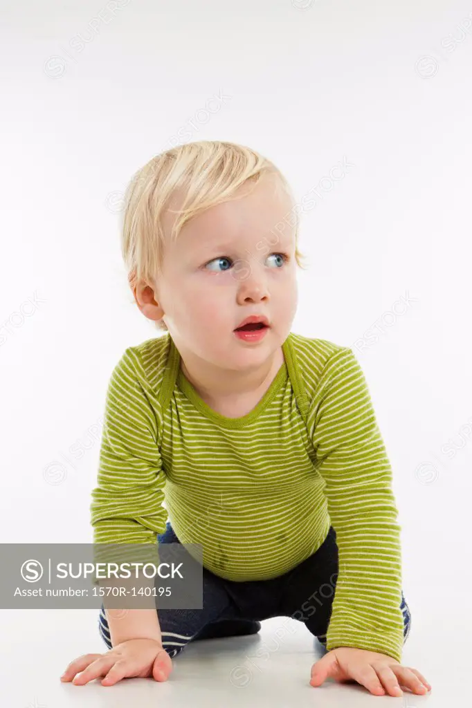 A toddler kneeling and looking away
