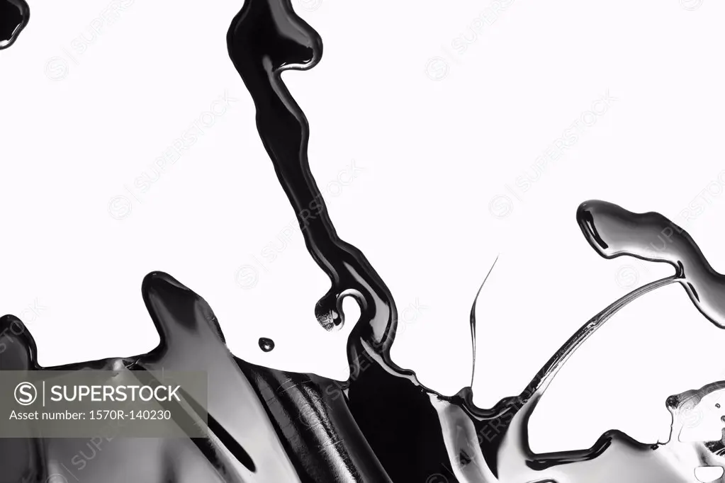 Spilled black paint making an abstract shape on white background