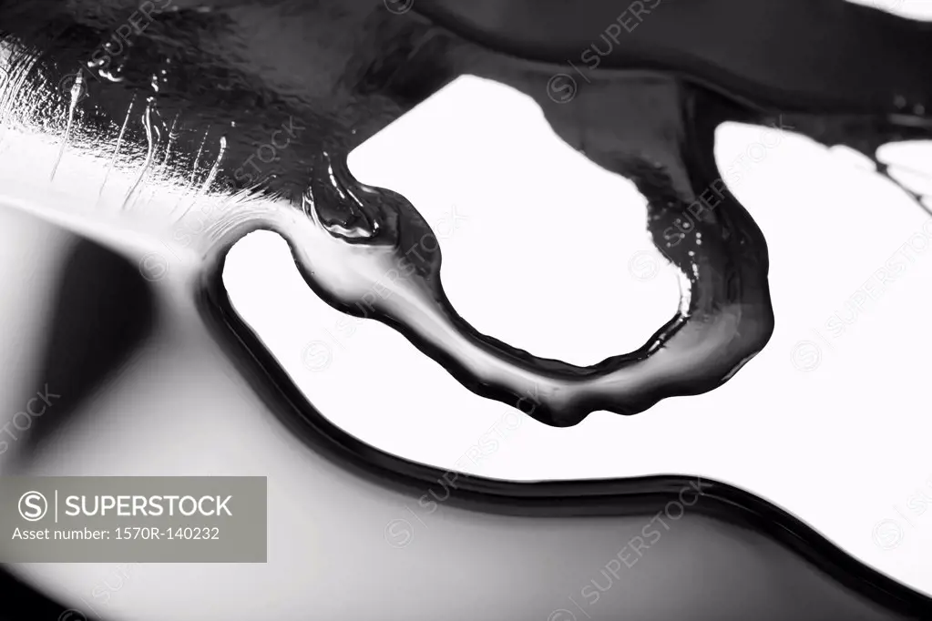Spilled black paint making an abstract shape on white background