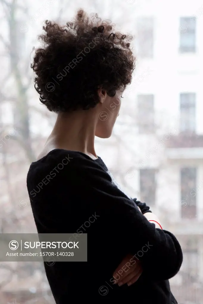 Side view of a woman looking through a window