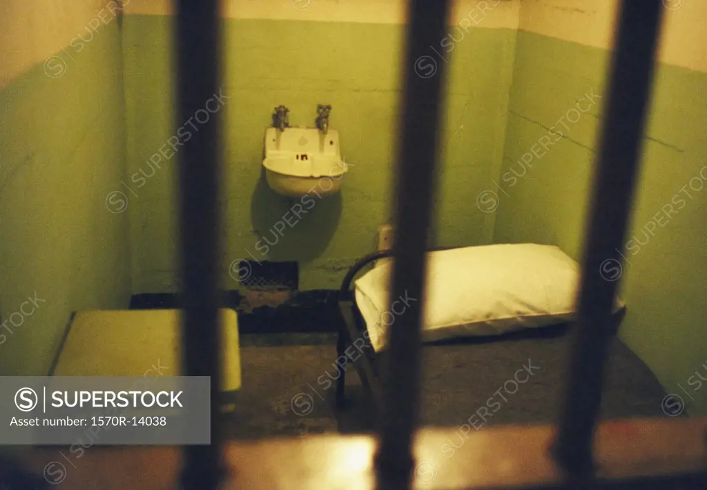 prison cell with sink and bed