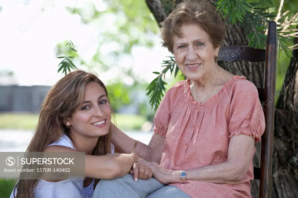Portrait of a senior woman and a young woman sitting together outside