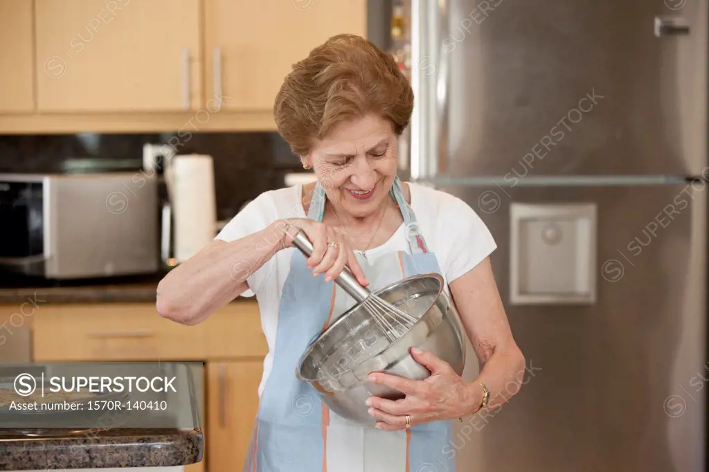A senior woman mixing ingredients in a bowl