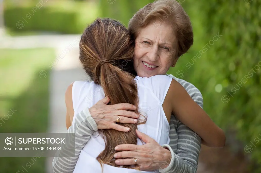 A senior woman hugging a young woman