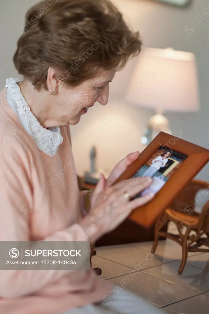 A senior woman holding a picture frame