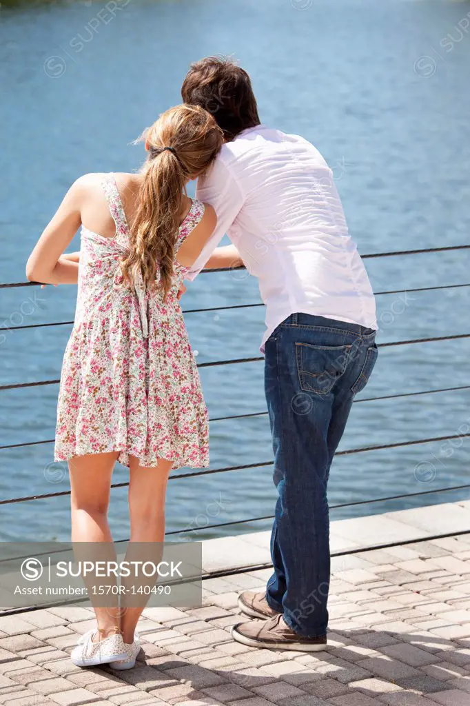 A young couple standing at a railing enjoying the lake view