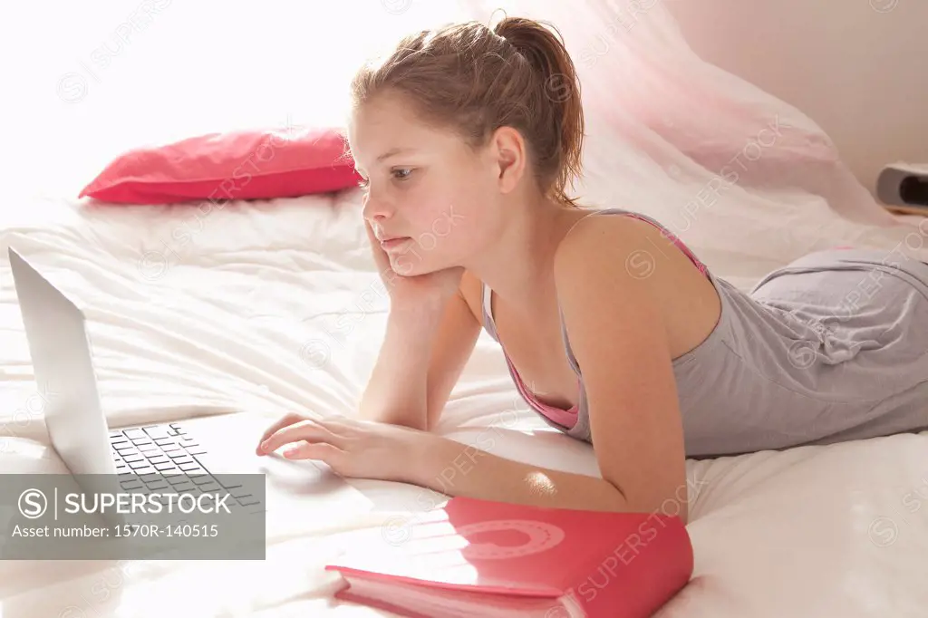 Girl on bed doing homework