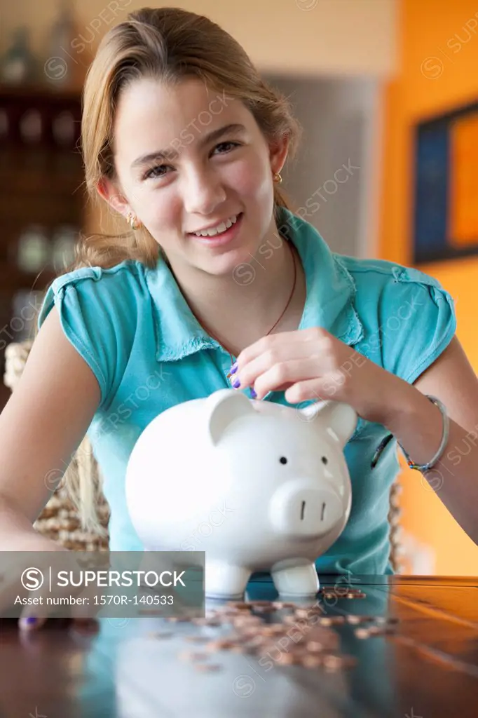 Girl puts coin in piggy bank