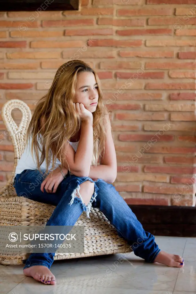Bored girl sitting on wicker chair