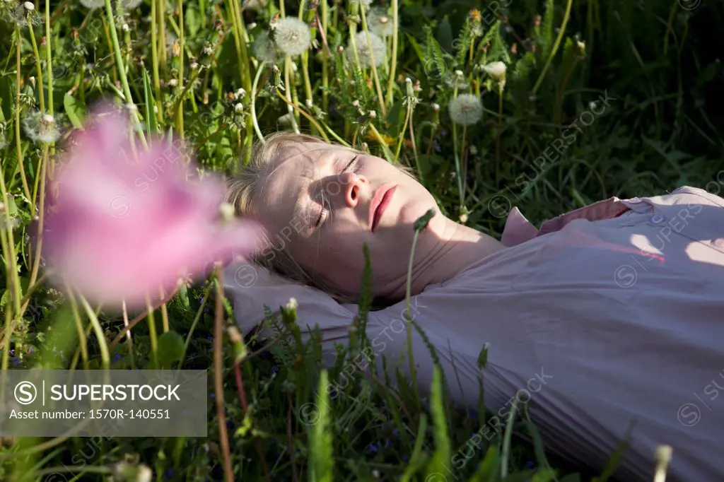 A woman lying in the grass sleeping, close-up