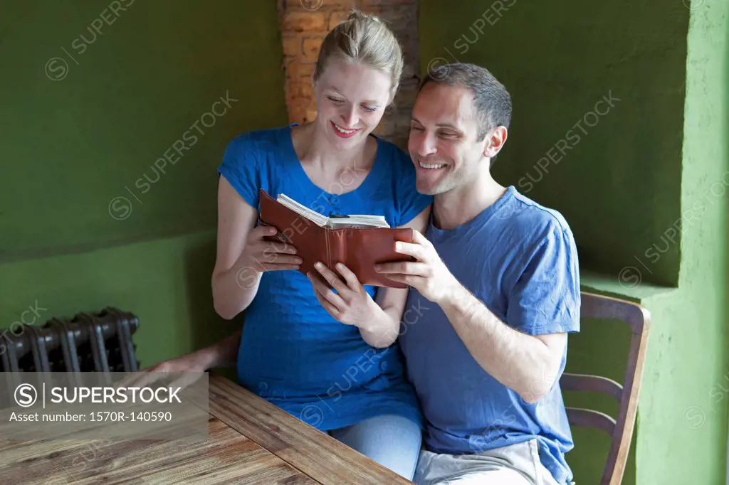 A couple reading a personal organizer together and smiling