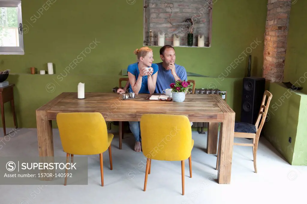 A couple with a personal organizer and coffee, looking contemplative