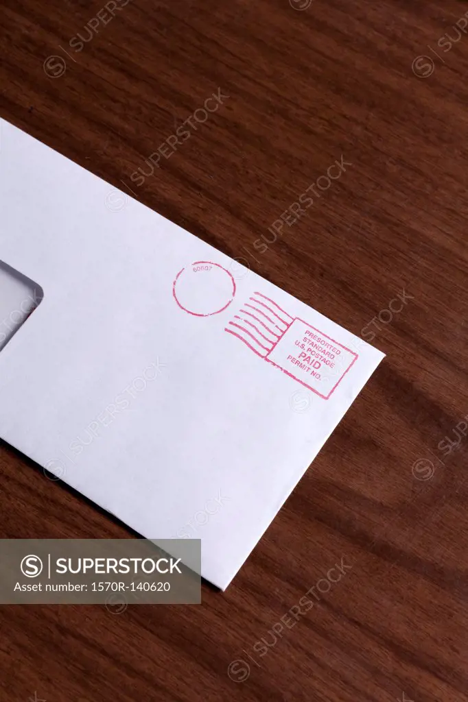 A window envelope with a red ink postage stamp