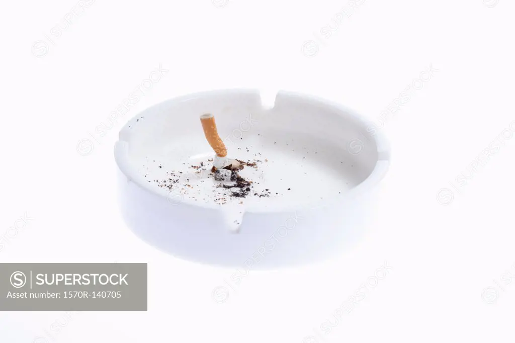 A cigarette butt put out in a white ashtray