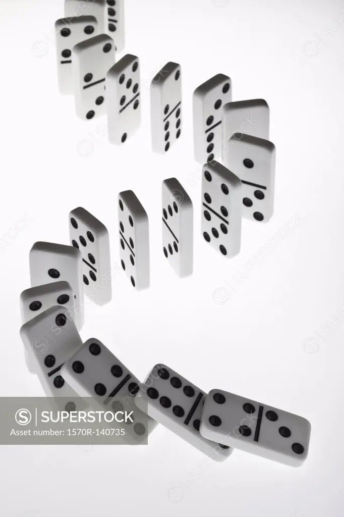 Dominoes in a row, beginning to fall over in a chain reaction