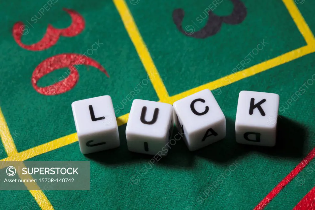 Dice on a gambling table spelling the word LUCK