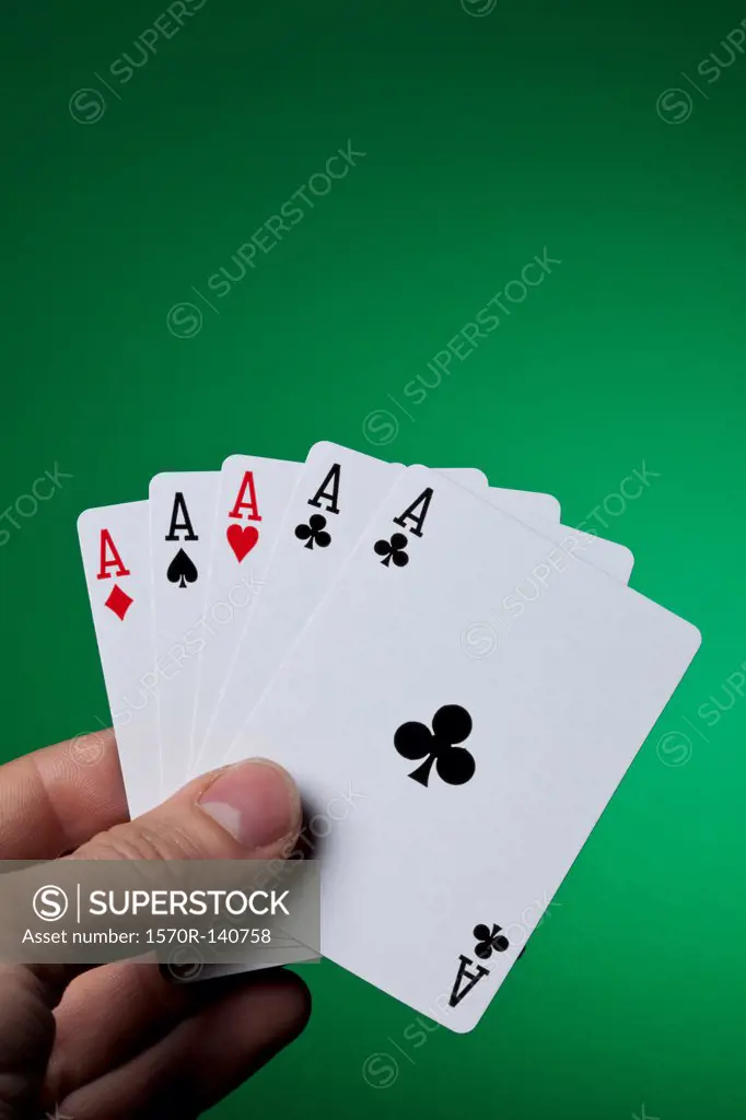 A hand holding five aces fanned out