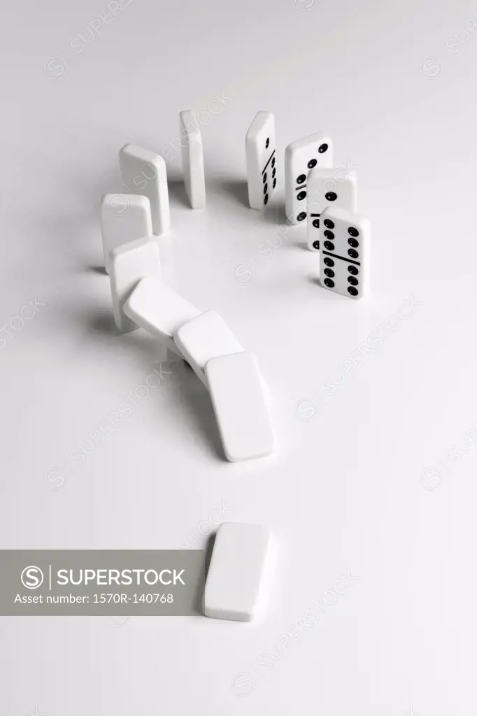 Dominoes arranged in a question mark falling over in a chain reaction