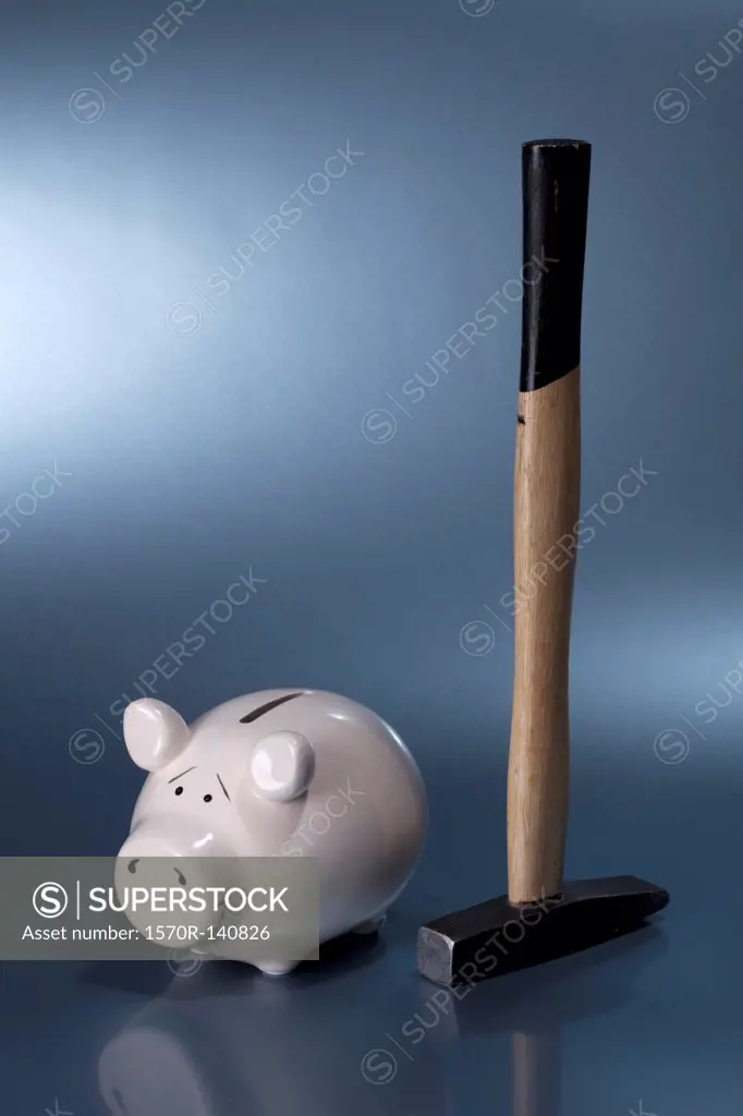 A sledgehammer next to a ceramic piggy bank