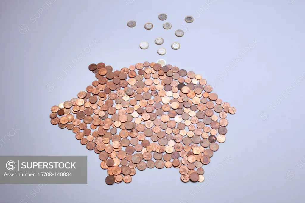 Euro coins falling into a piggy bank made from arranged European coins