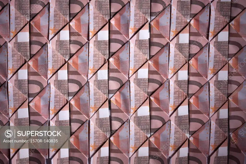 Ten Euro banknotes folded into diamond shapes and interwoven, full frame