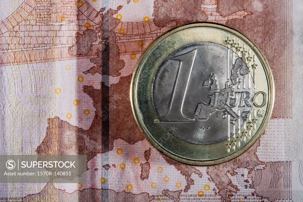 Detail of a ten Euro banknote with a one Euro coin on top of it