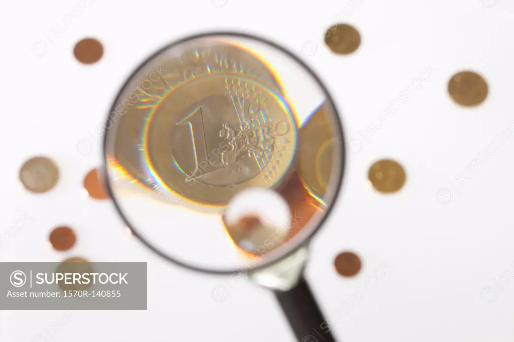 A magnifying glass magnifying a one Euro coin