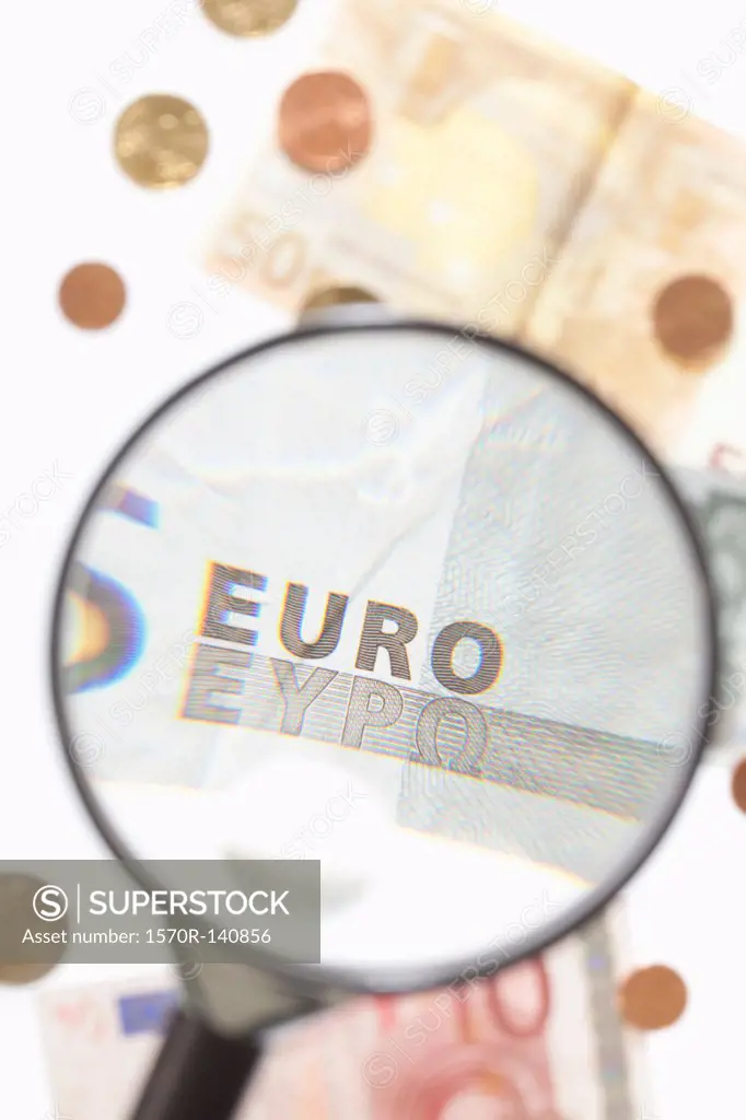 A magnifying glass magnifying a five Euro banknote