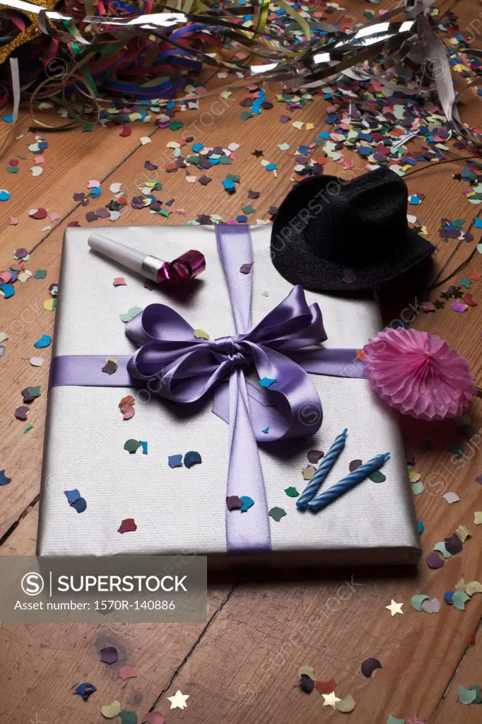 A gift surround by confetti and party decorations