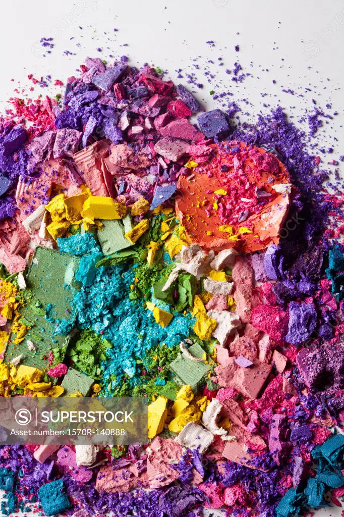 Various crushed up make-up powder products arranged in an abstract pattern