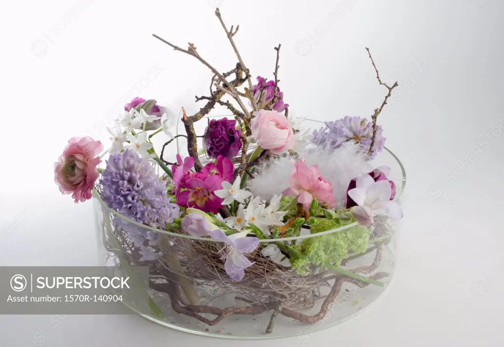 A glass bowel vase with an arrangement of various flowers