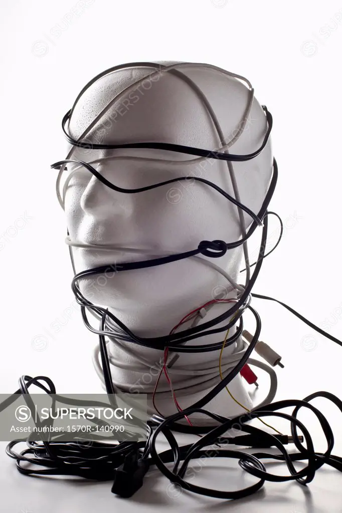 A white mannequin bust entangled in various cords and cables