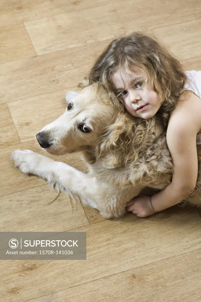 A young girl hugging a dog