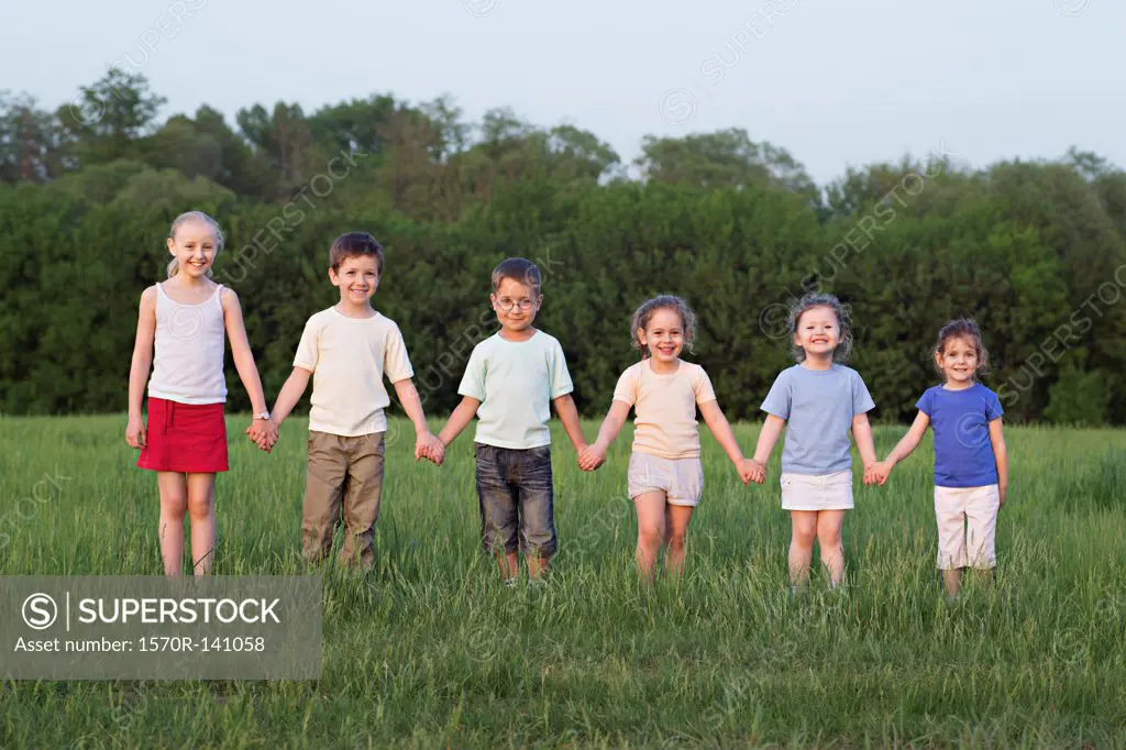 Portrait of children holding hands in a field