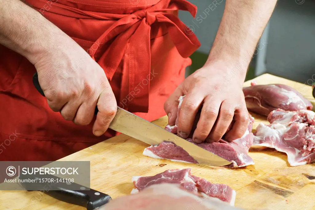 Detail of a man slicing meat