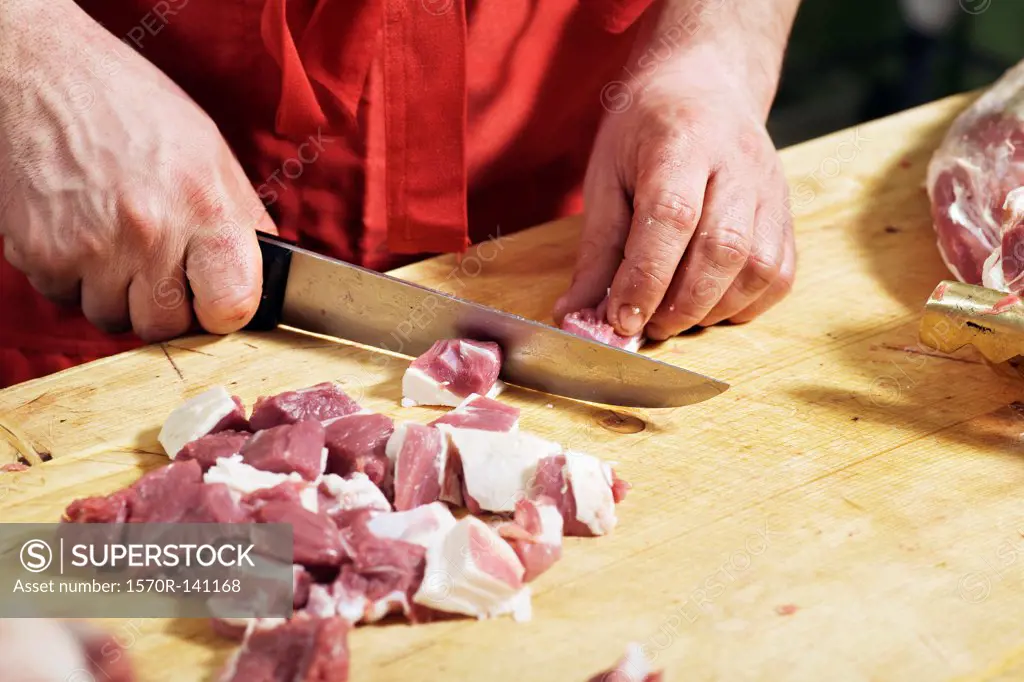 Detail of a man chopping meat