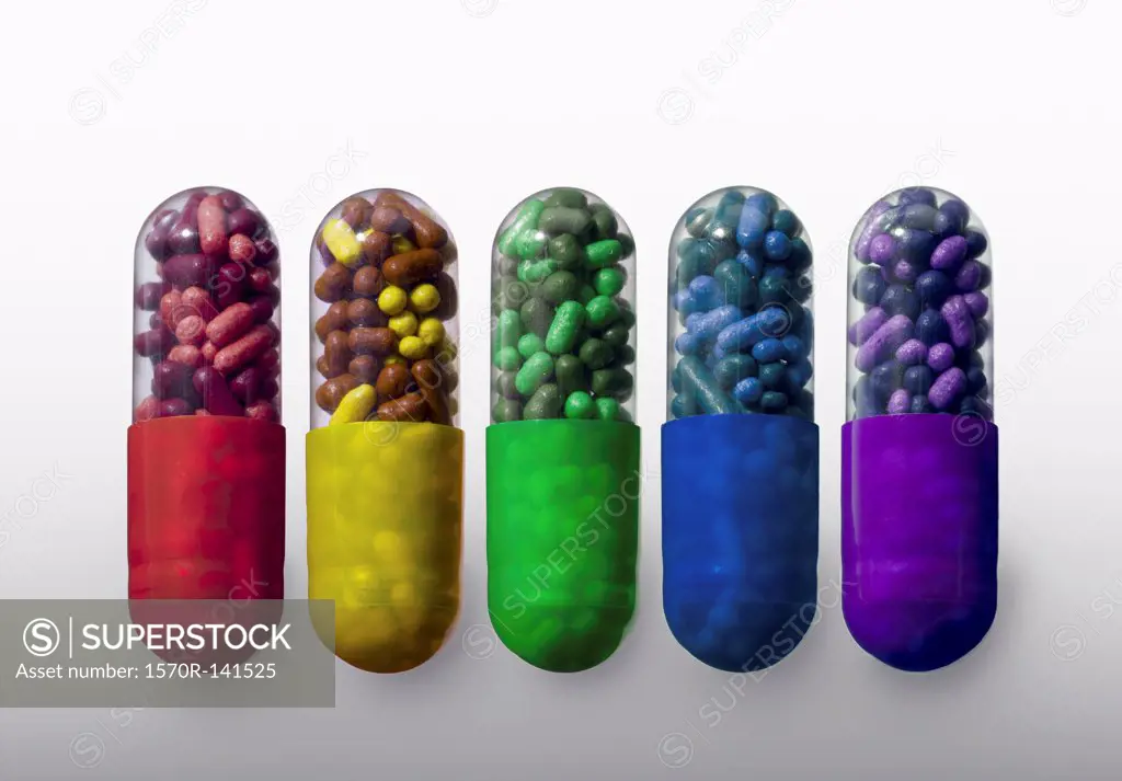 A row of vibrantly variously colored capsule pills, close-up