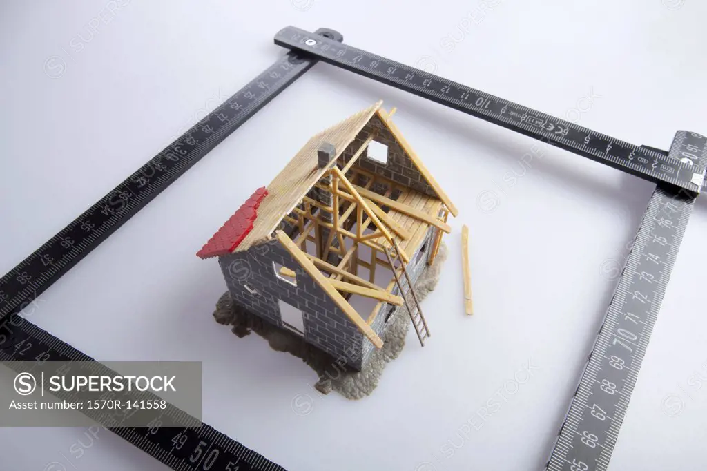 A partially constructed model of a house and a folding ruler