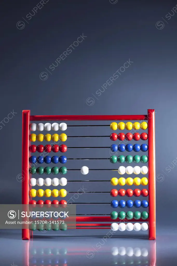 An abacus with neat rows of multi colored beads and a single white bead in the middle