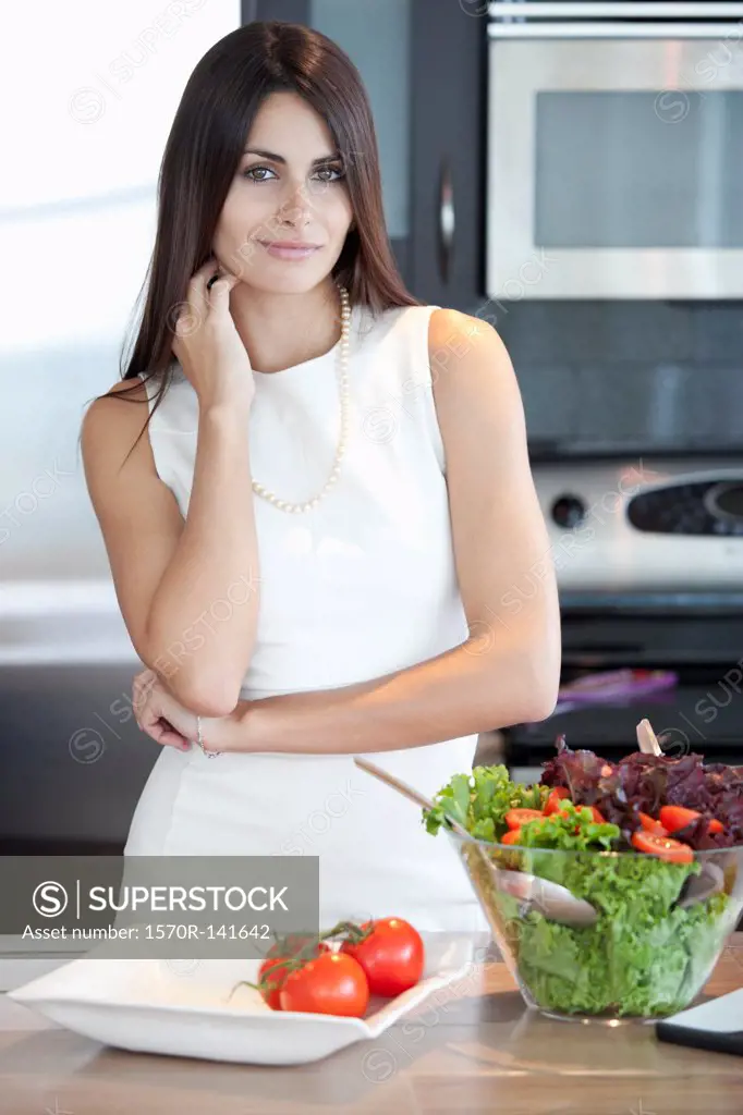 Elegant woman in kitchen with bowl of salad