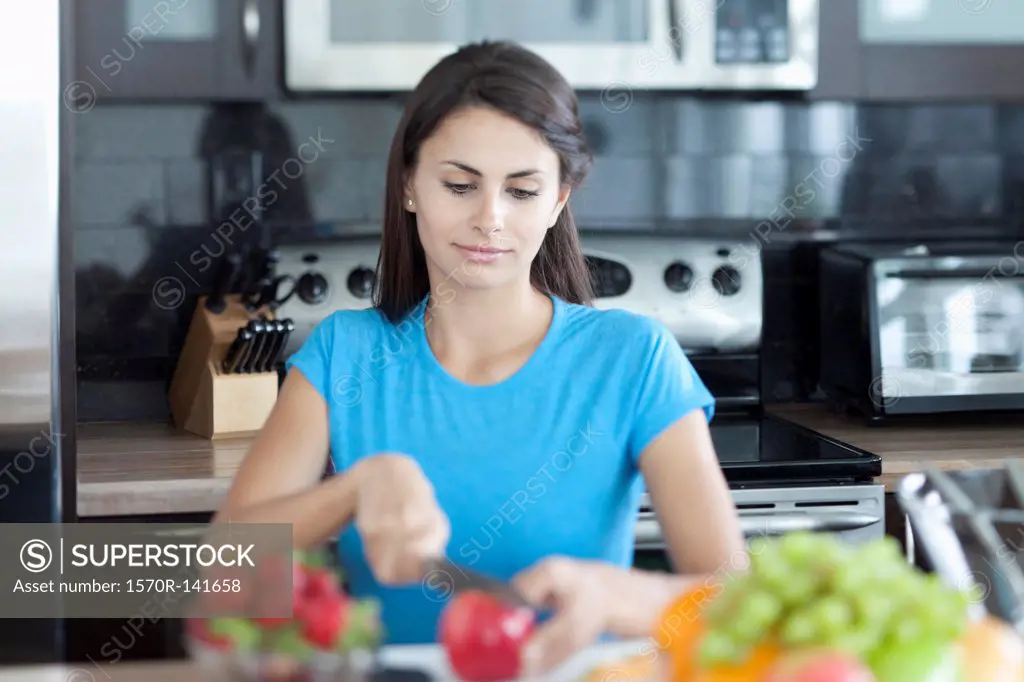 Woman slicing apple in kitchen