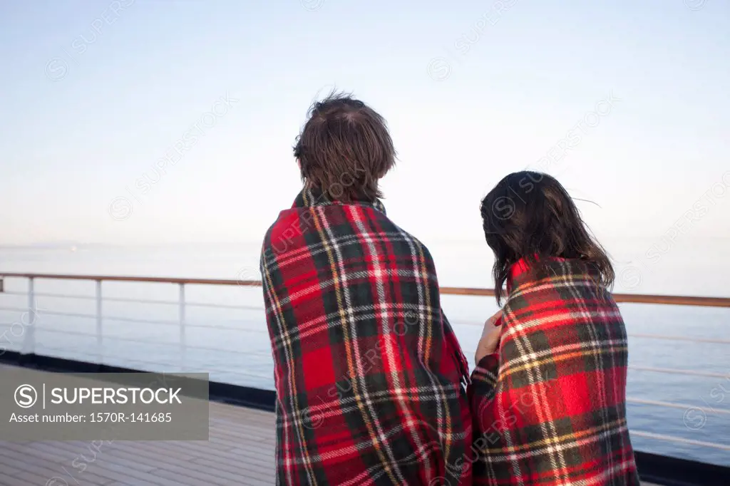 A couple on a ship deck, wrapped in blankets, looking at view, Seattle, Washington, USA
