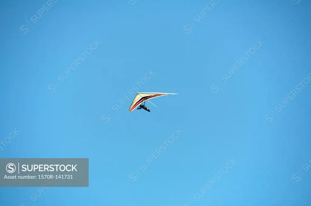 Hang glider against a clear blue sky
