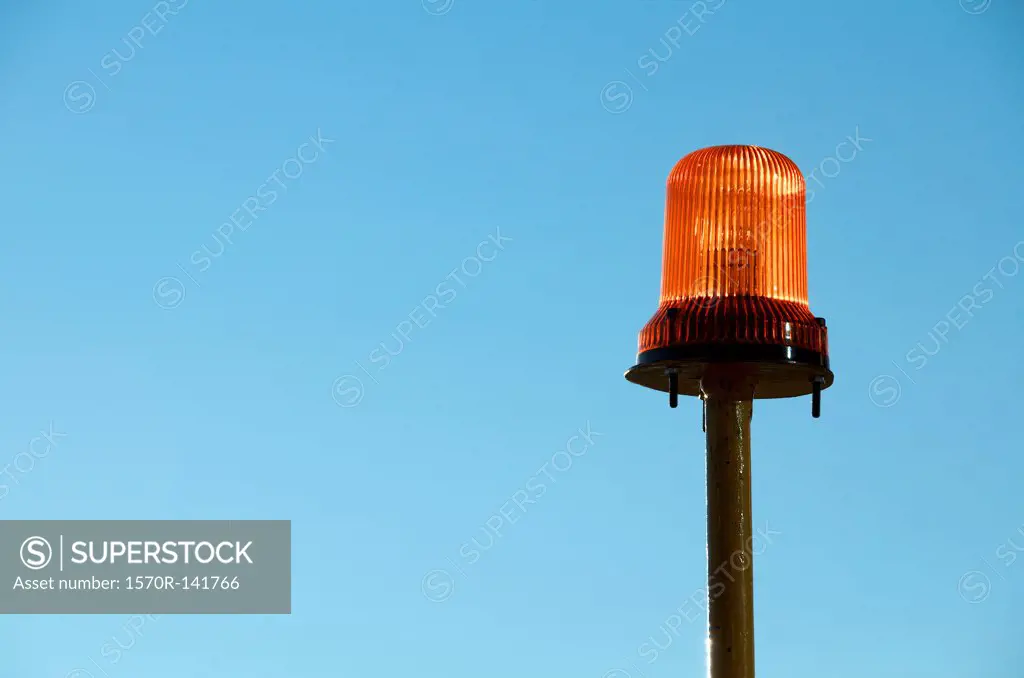 Warning light with blue background of sky