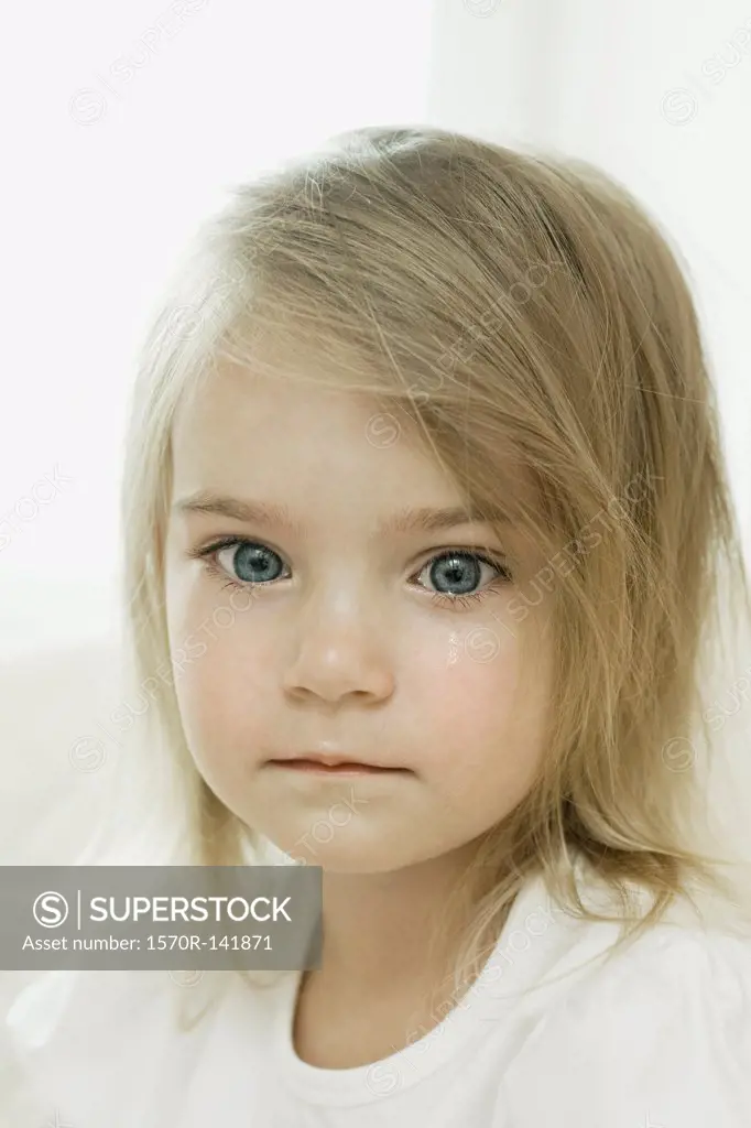 A young girl with a tear falling down her cheek