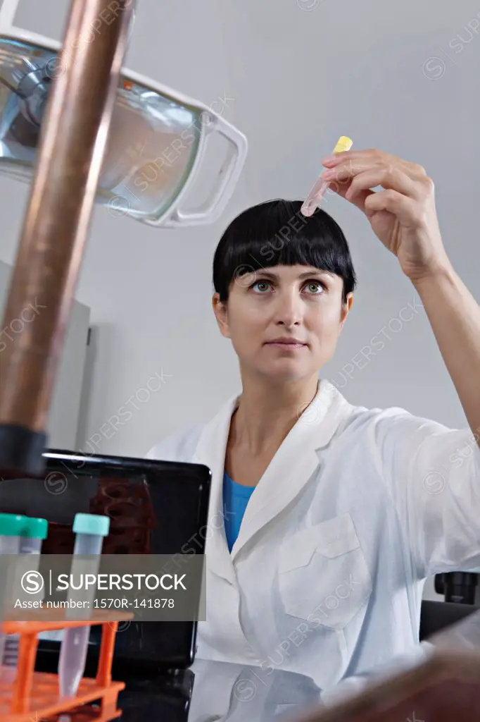 A lab technician examining a test tube full of liquid