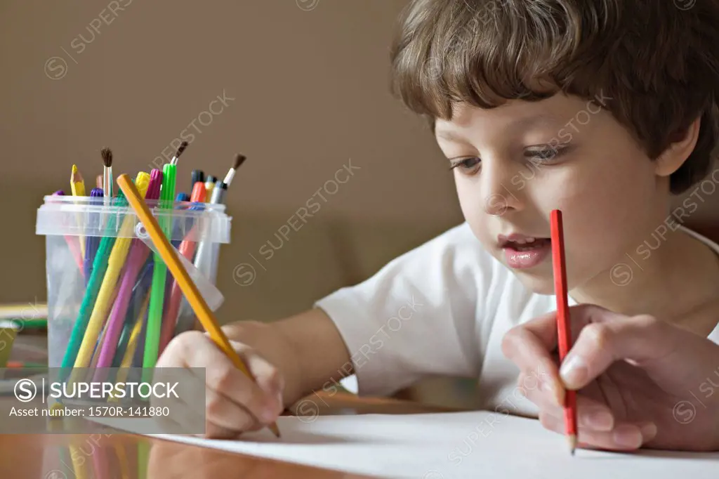 A boy and a friend drawing with colored pencils, viewpoint of boy