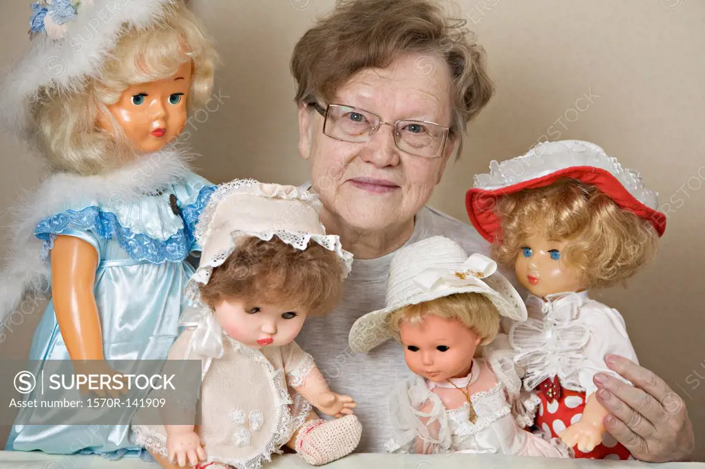 A senior woman with her collection of old-fashioned dolls