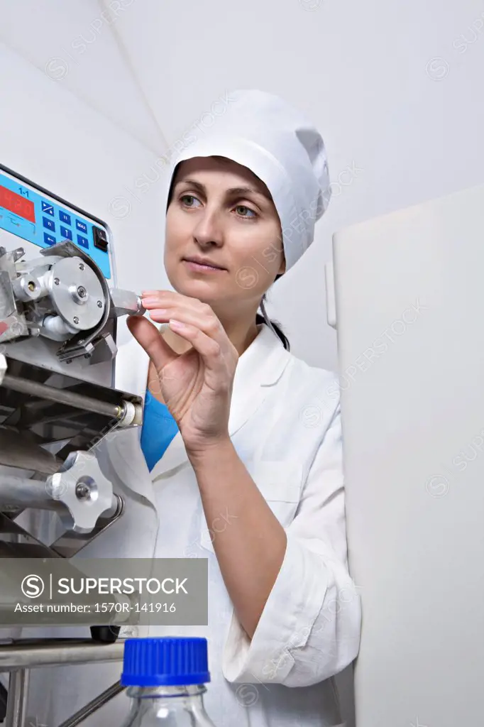 A lab technician adjust a knob on diagnostic medical equipment